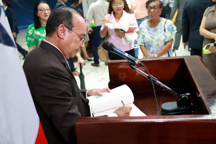 El Dr. Eduardo Flores Castro autografía un ejemplar del libro de historia